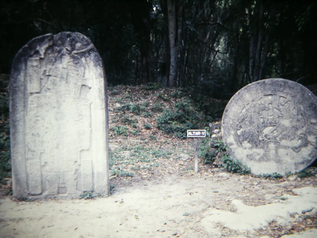 Carved stela and altar under the trees
